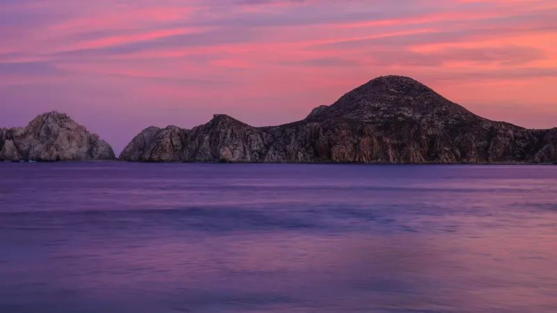 Cielo rosa y morado del atardecer sobre las rocas de Land's End, en Cabo San Lucas